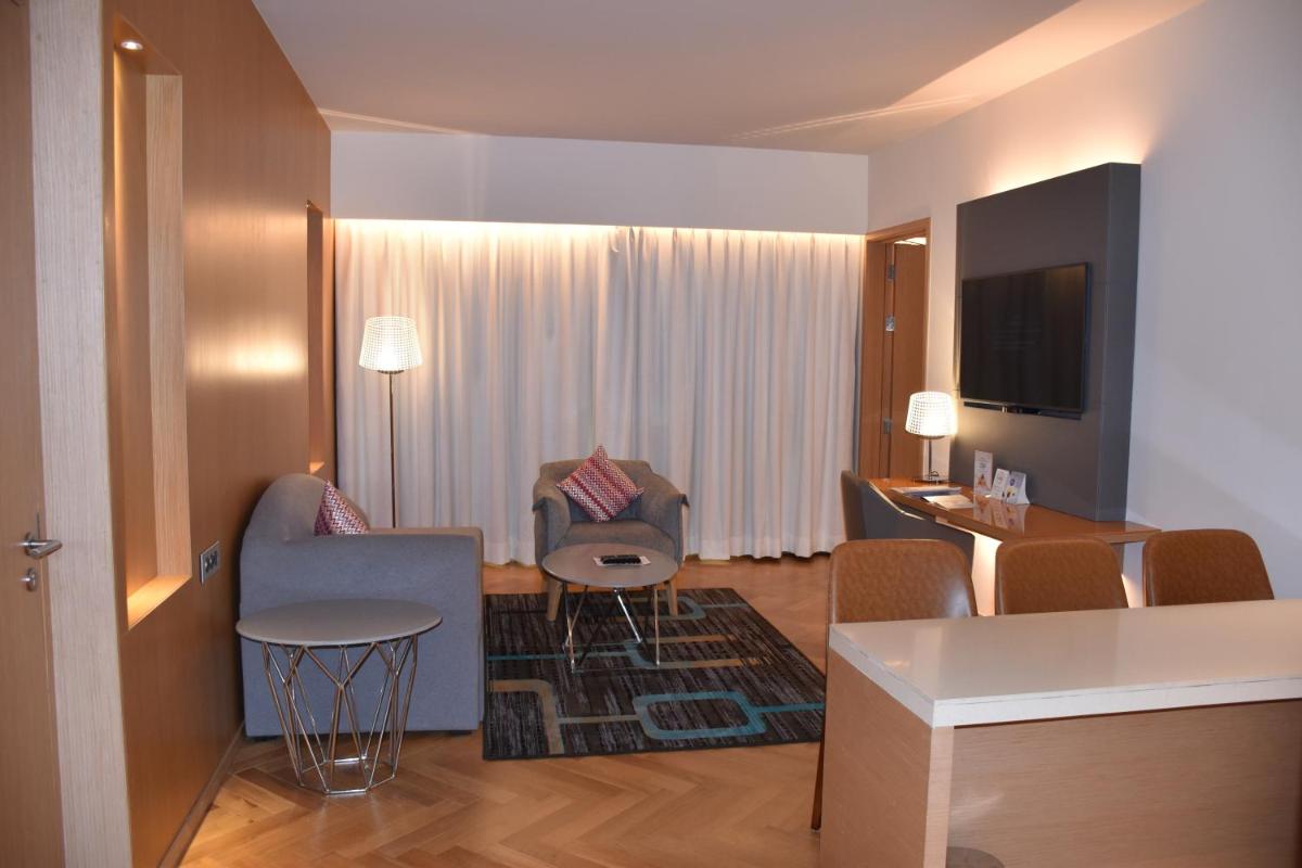 a hotel room with a living area and a living room at Novotel Vijayawada Varun in Vijayawāda