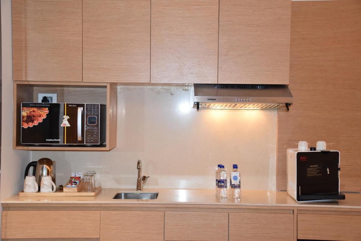 a kitchen with a sink and a microwave at Novotel Vijayawada Varun in Vijayawāda
