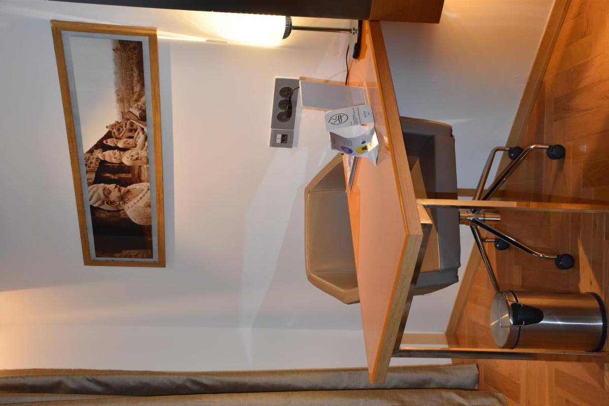 a room with a wall with a mirror and a desk at Novotel Vijayawada Varun in Vijayawāda