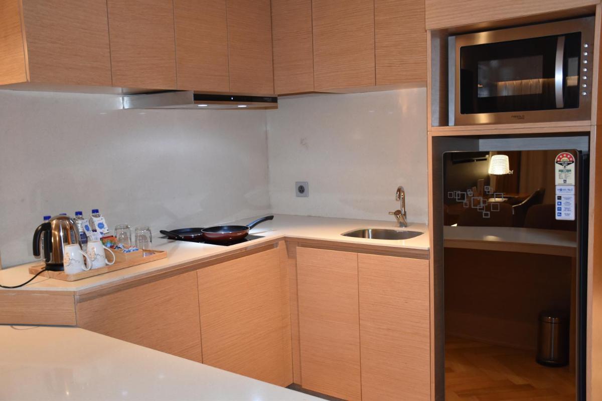 a small kitchen with a sink and a microwave at Novotel Vijayawada Varun in Vijayawāda