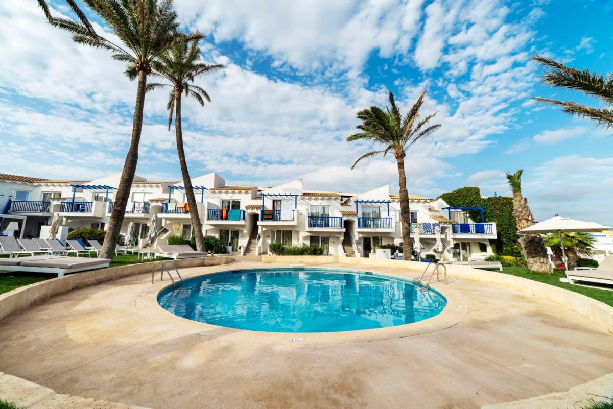 una gran piscina frente a una casa grande en Parque Nereida Suites Hotel, en Cala Ratjada