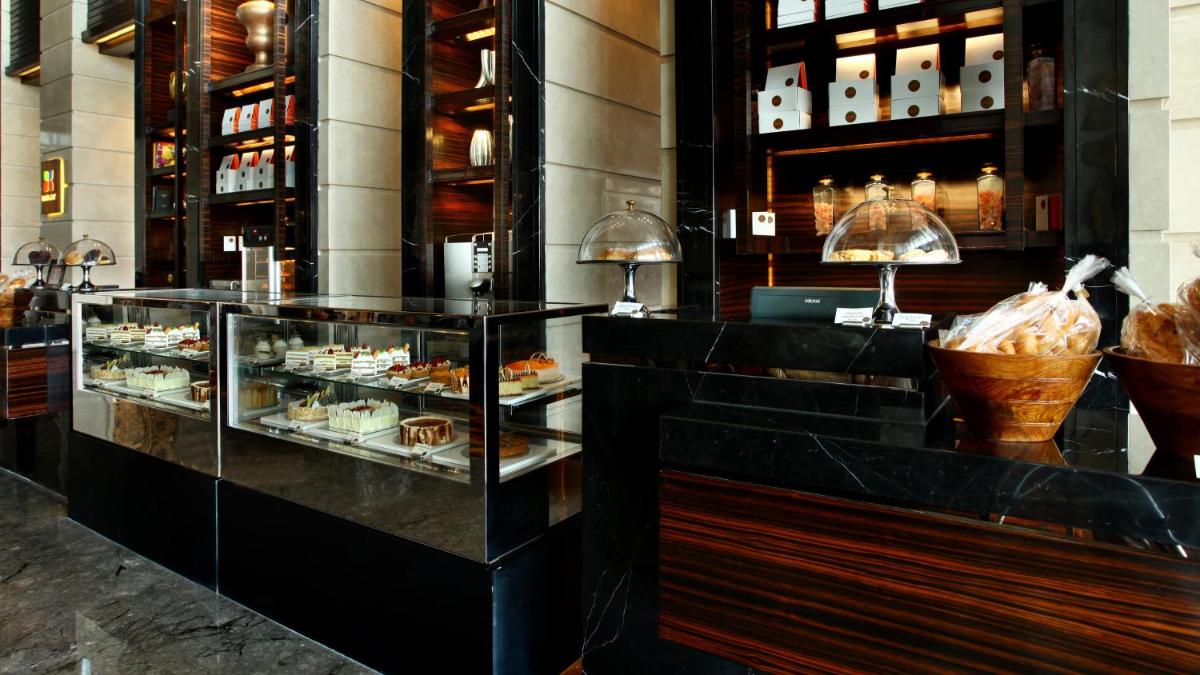 a restaurant with a display case filled with pastries at Crowne Plaza New Delhi Rohini by IHG in New Delhi a restaurant with a display case filled with pastries at Crowne Plaza New Delhi Rohini by IHG in New Delhi