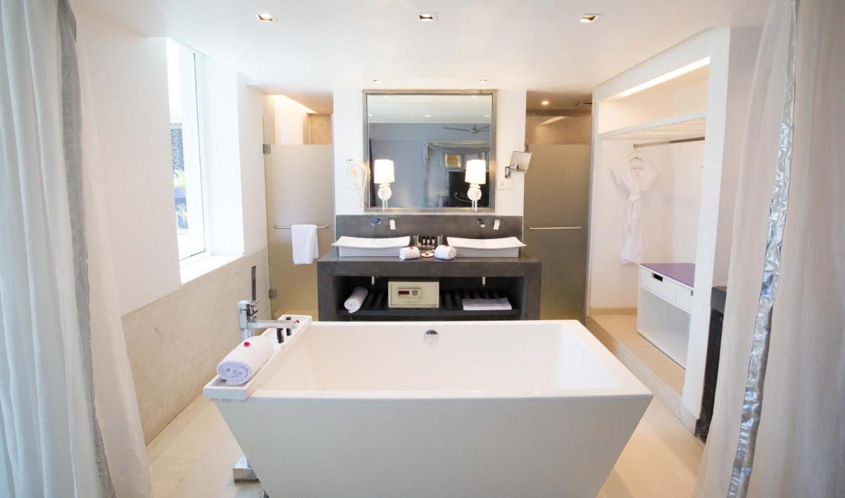 a bathroom with a large white tub and a mirror at The Park Calangute Goa in Calangute a bathroom with a large white tub and a mirror at The Park Calangute Goa in Calangute