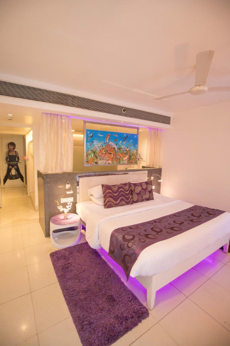 a bedroom with a large bed with purple lighting at The Park Calangute Goa in Calangute a bedroom with a large bed with purple lighting at The Park Calangute Goa in Calangute