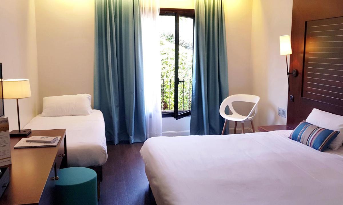 Un ou plusieurs lits dans un hébergement de l'établissement Hôtel Les Jardins De Sainte-Maxime
