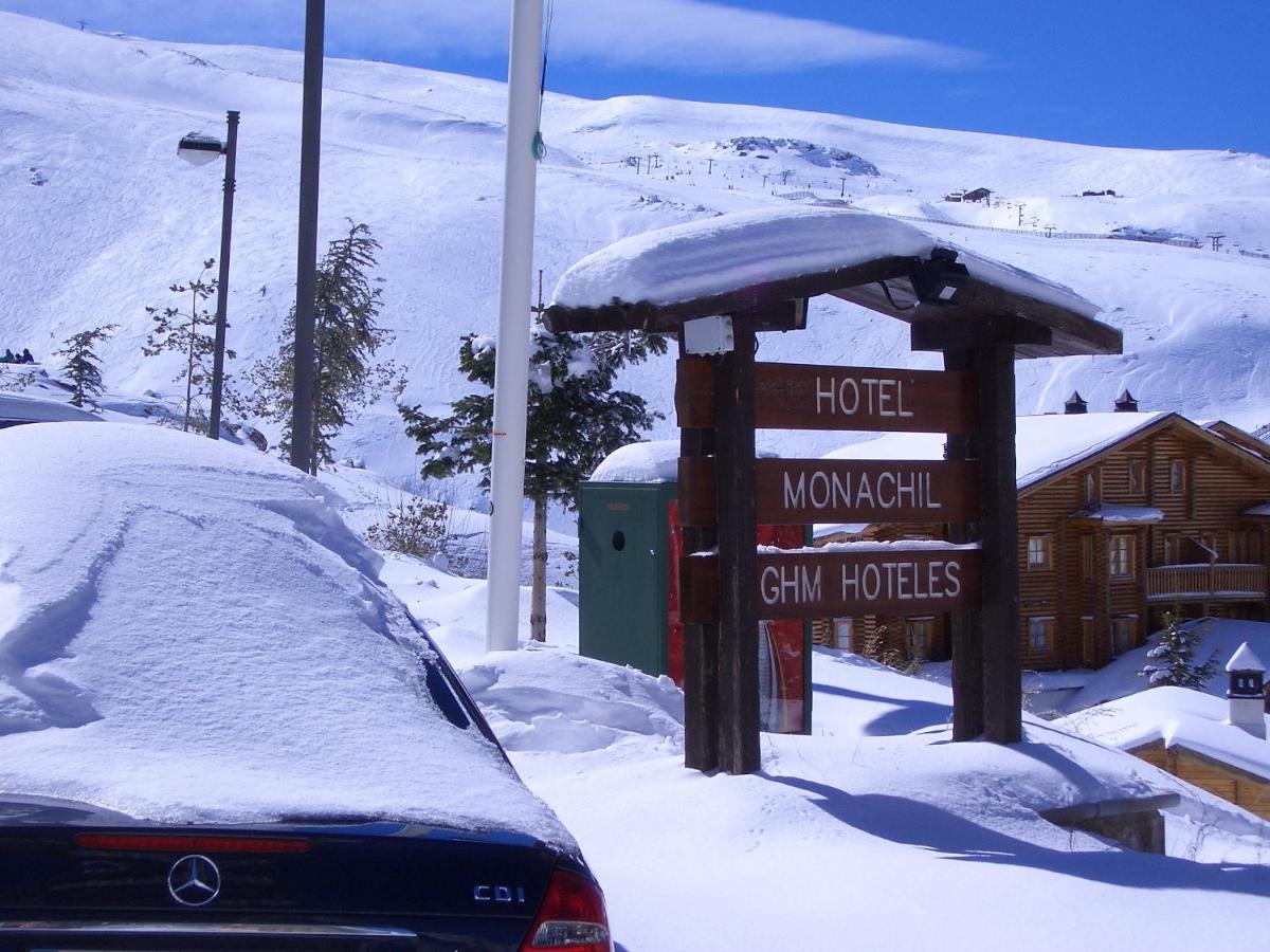 Un cartel en la nieve frente a un hotel. en Hotel GHM Monachil, en Sierra Nevada