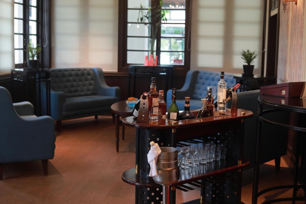 a room with chairs and tables with bottles and glasses at Savoy - IHCL SeleQtions in Ooty