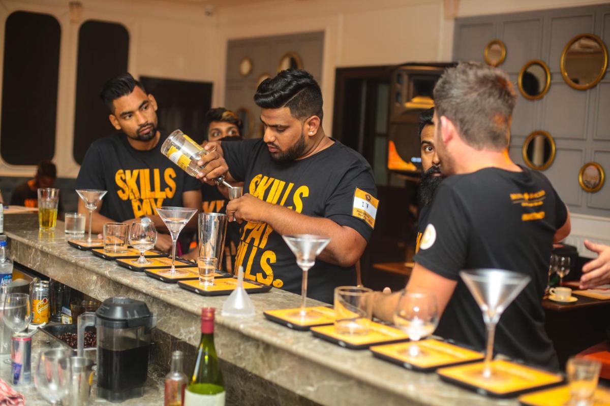 a group of men standing around a bar preparing drinks at Savoy - IHCL SeleQtions in Ooty