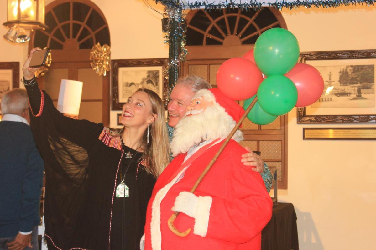 a man dressed as santa claus holding a bunch of balloons at Savoy - IHCL SeleQtions in Ooty