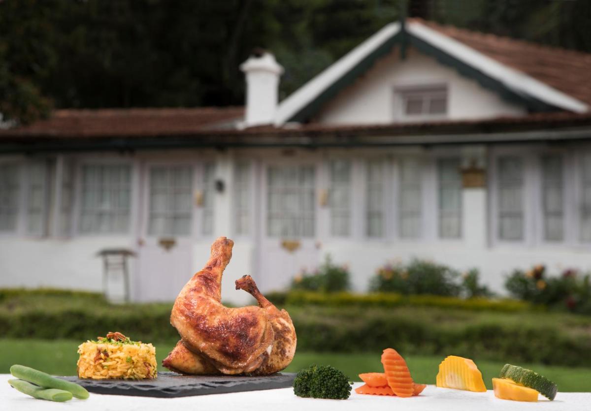 a chicken sitting on a table with some vegetables at Savoy - IHCL SeleQtions in Ooty