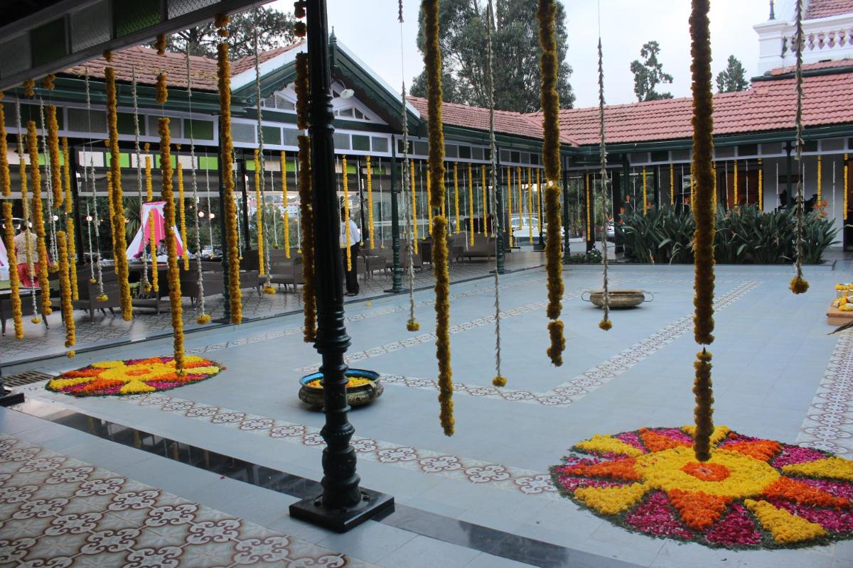 a courtyard with flowers in front of a building at Savoy - IHCL SeleQtions in Ooty