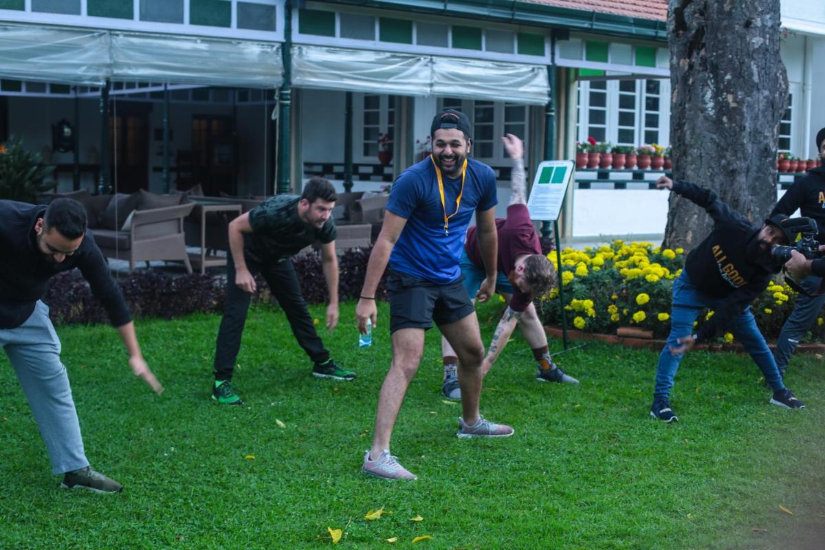 a group of people playing frisbee in the grass at Savoy - IHCL SeleQtions in Ooty