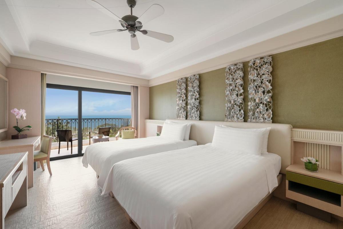 two beds in a hotel room with a balcony at Shangri-La Rasa Sentosa, Singapore in Singapore