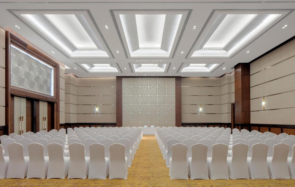 an empty hall with white chairs in a room at Radisson Blu Plaza Hotel Mysore in Mysore