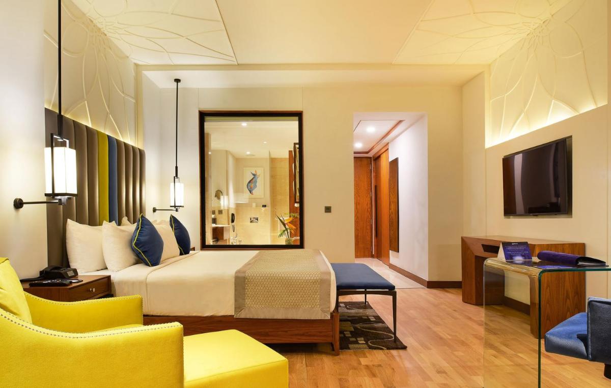 a hotel room with a bed and a television at Radisson Blu Plaza Hotel Mysore in Mysore