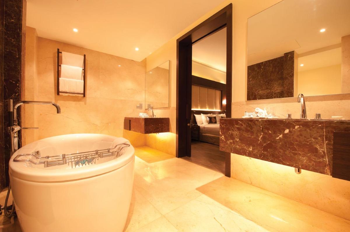 a bathroom with a large tub and a sink at Radisson Blu Plaza Hotel Mysore in Mysore