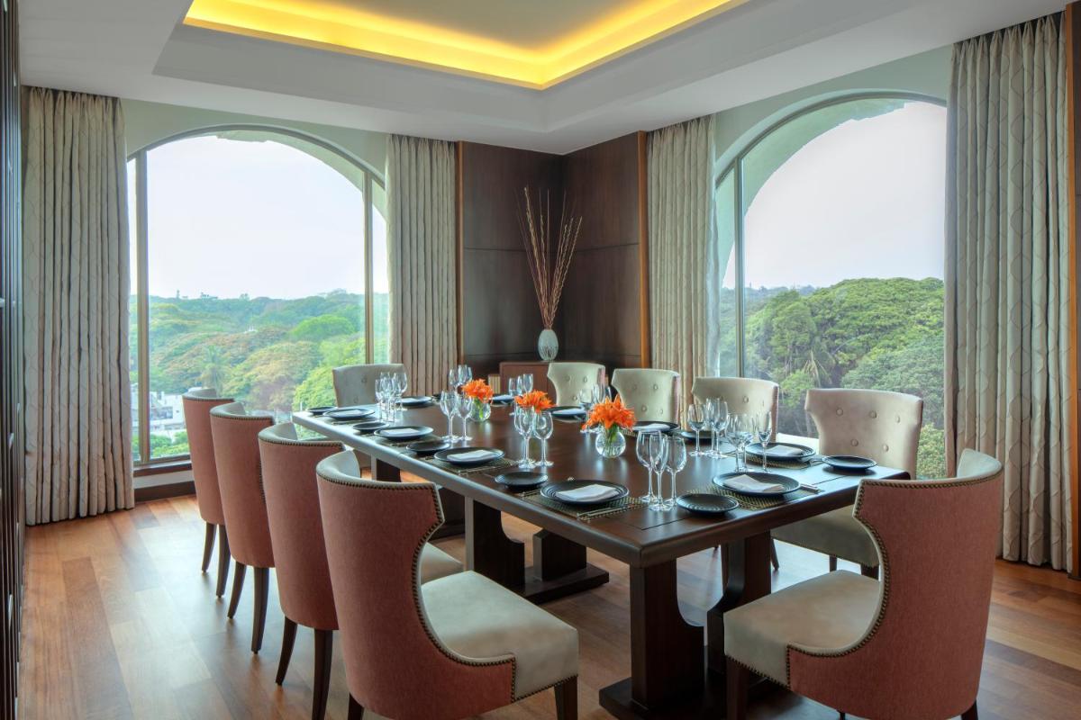 a dining room with a long table and chairs at Radisson Blu Plaza Hotel Mysore in Mysore