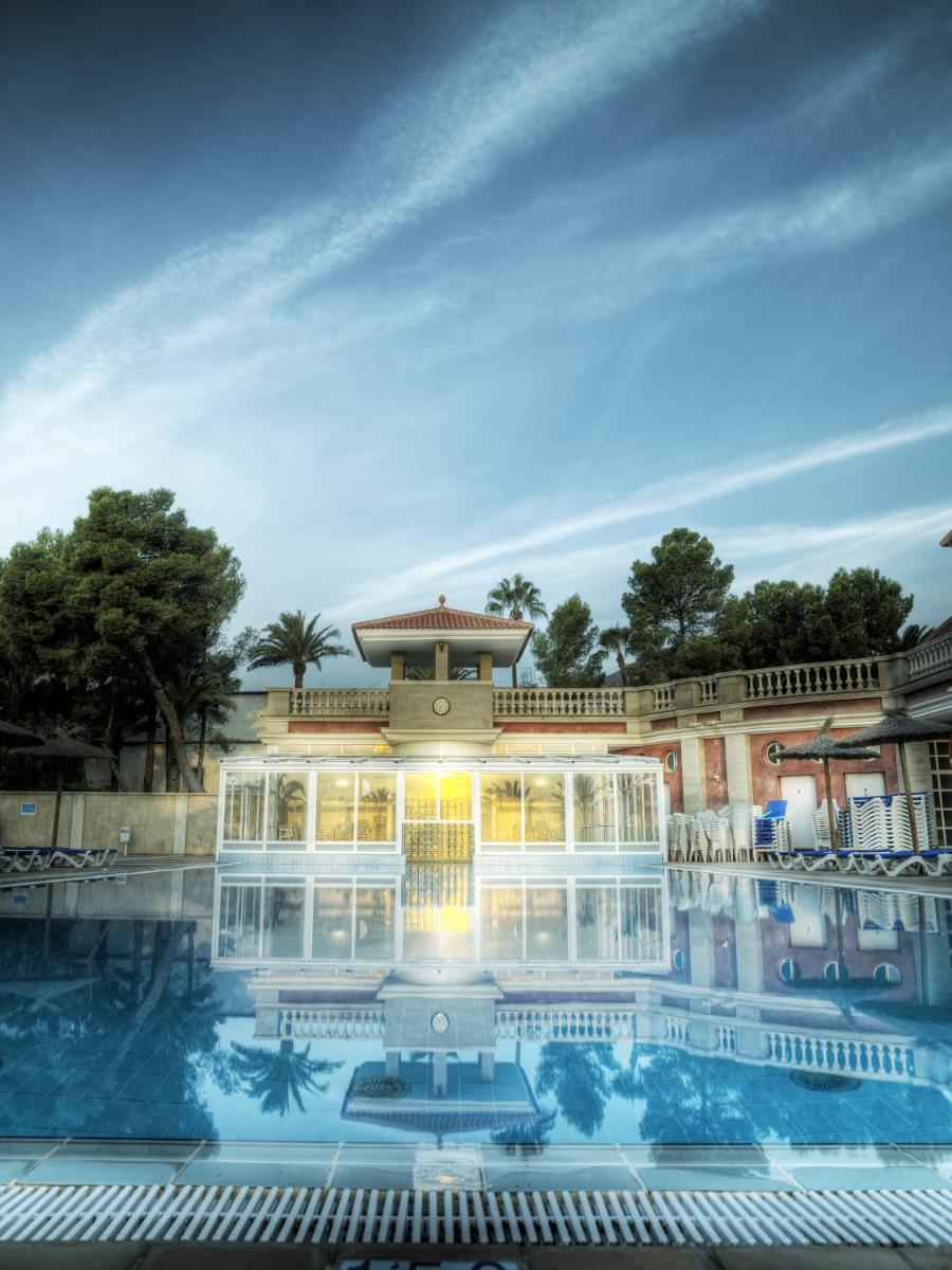 Un gran edificio con una piscina en frente. en Hotel Victoria, en Fortuna