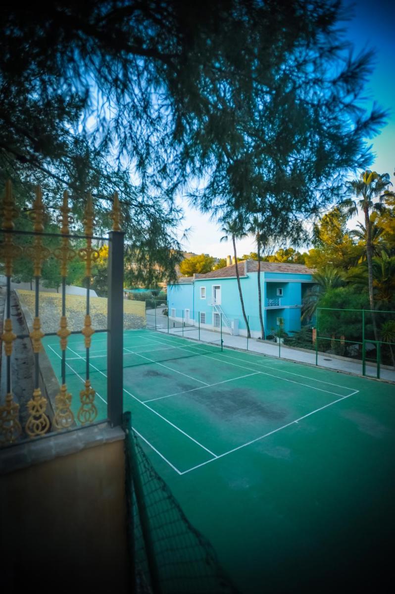 una cancha de tenis frente a una casa en Hotel Victoria, en Fortuna
