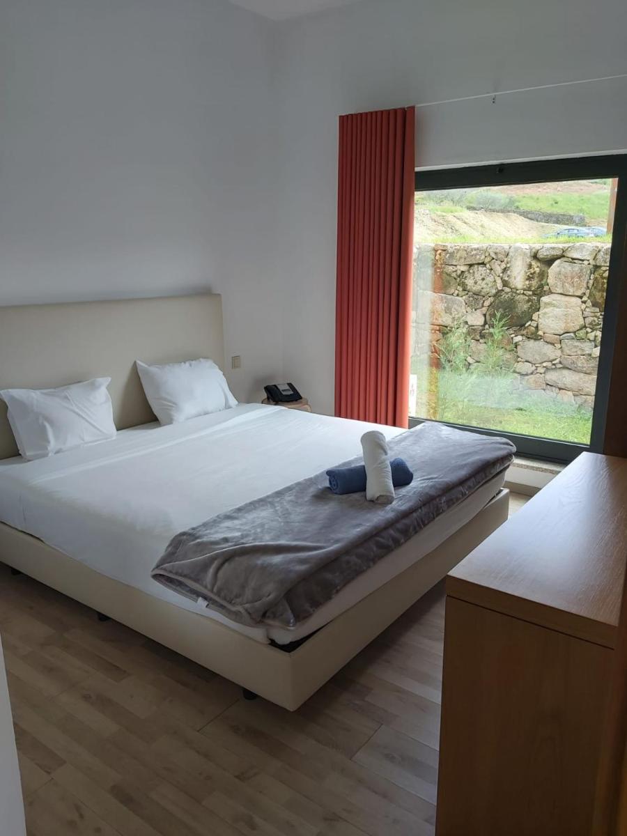 um quarto com uma cama grande e uma janela grande em Douro Cister Hotel Resort em Ucanha mais 61 fotografias