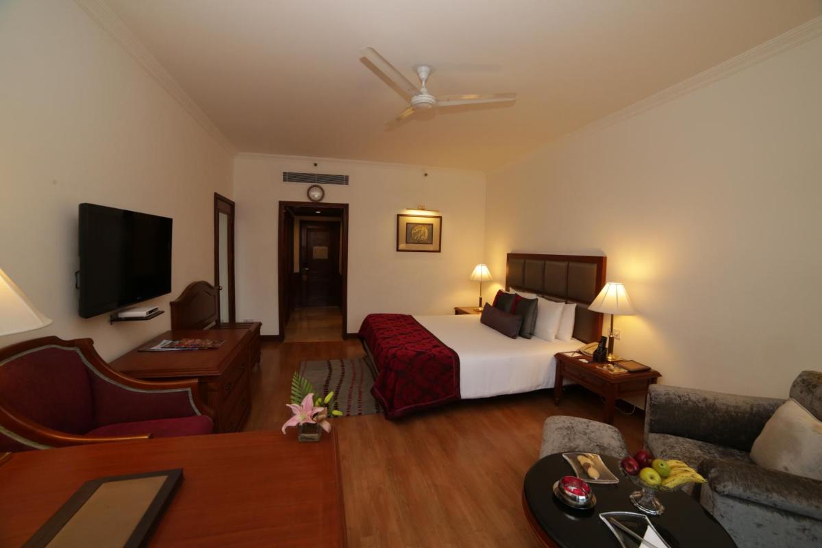 a hotel room with a bed and a couch at Jaypee Palace Hotel in Agra