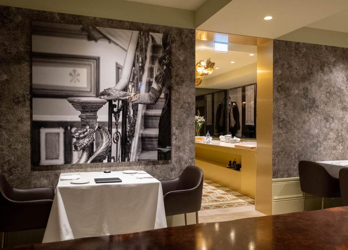 uma sala de jantar com uma mesa e um espelho em Vila Foz Hotel & SPA - member of Design Hotels no Porto