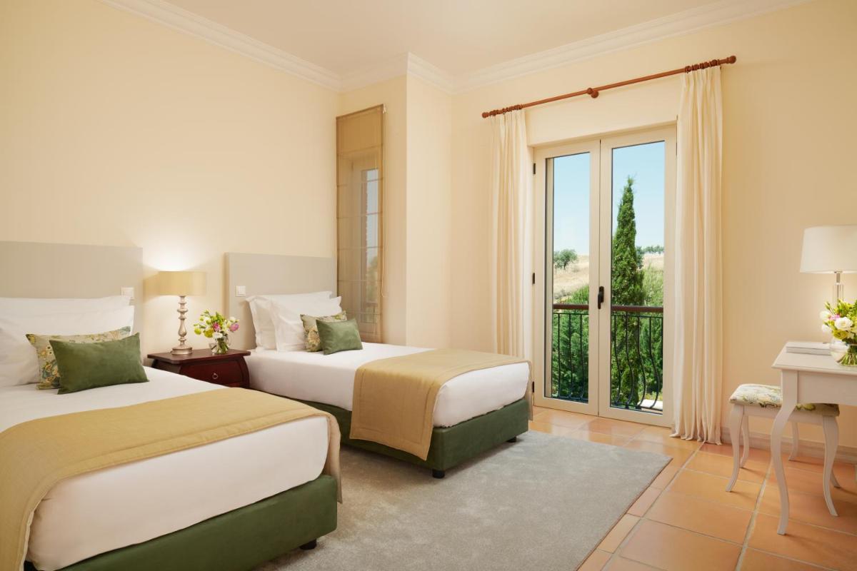 um quarto de hotel com duas camas e uma varanda em Monte Rei Golf & Country Club em Vila Nova de Cacela