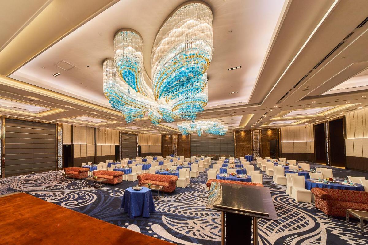 a banquet hall with a large chandelier and tables at Crowne Plaza New Delhi Rohini by IHG in New Delhi a banquet hall with a large chandelier and tables at Crowne Plaza New Delhi Rohini by IHG in New Delhi