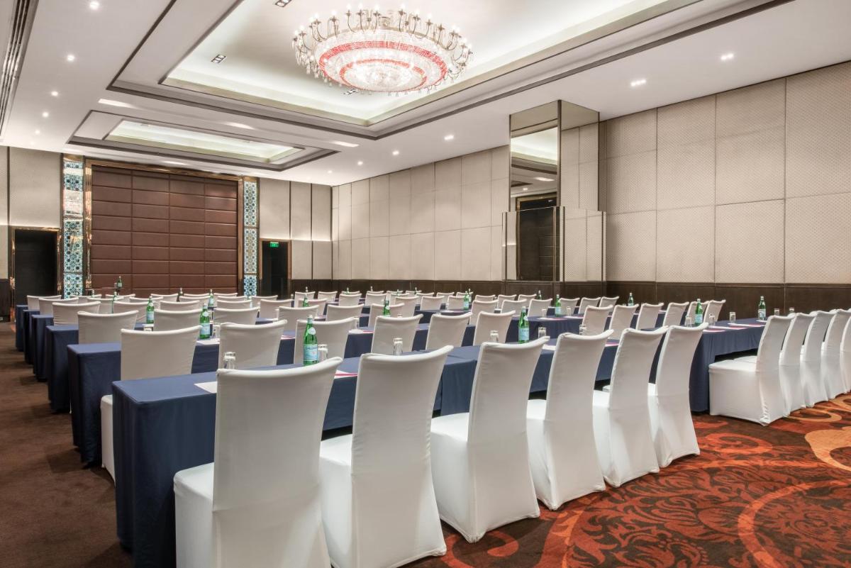 a conference room with rows of tables and chairs at Crowne Plaza New Delhi Rohini by IHG in New Delhi a conference room with rows of tables and chairs at Crowne Plaza New Delhi Rohini by IHG in New Delhi