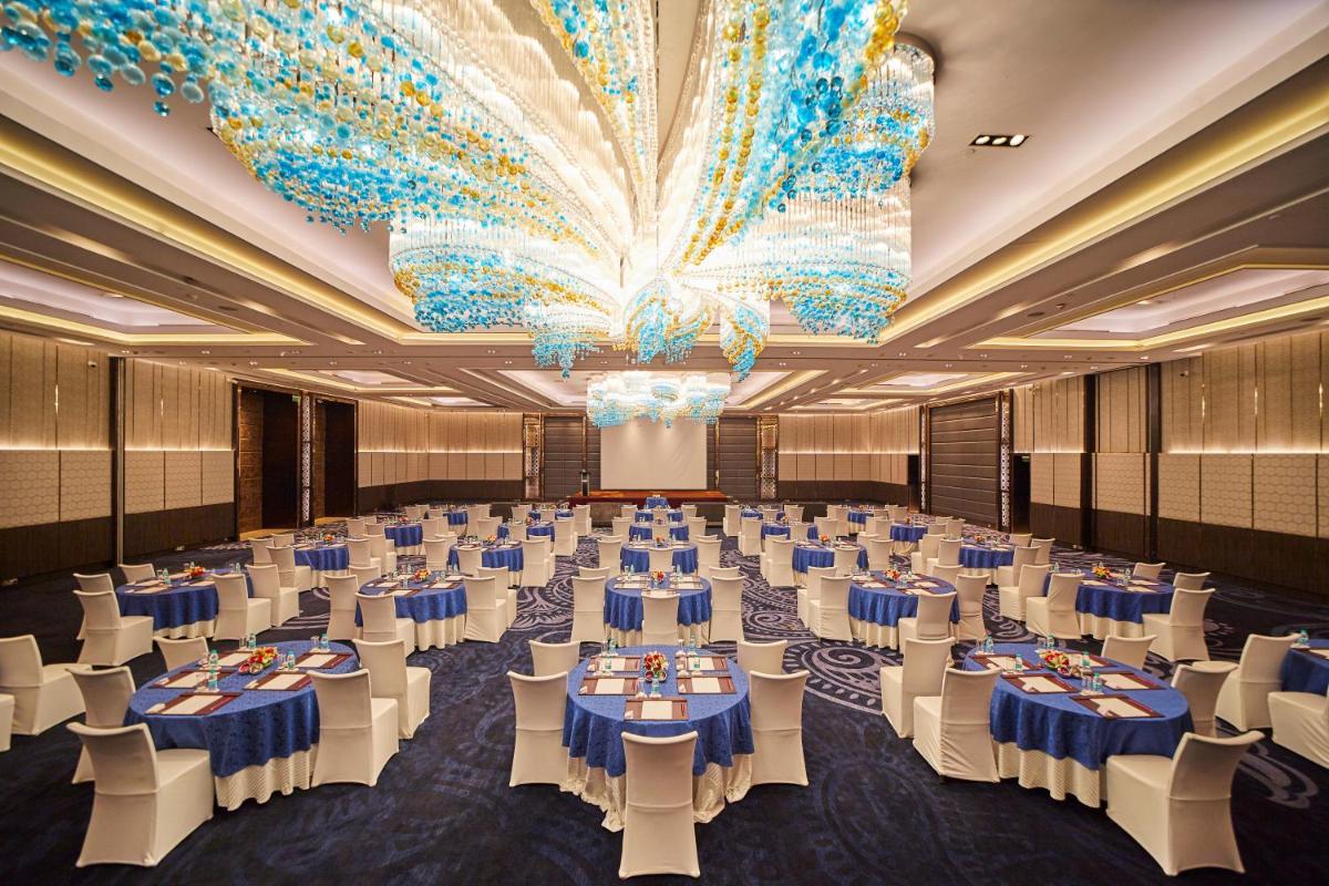 a large banquet hall with blue tables and white chairs at Crowne Plaza New Delhi Rohini by IHG in New Delhi a large banquet hall with blue tables and white chairs at Crowne Plaza New Delhi Rohini by IHG in New Delhi