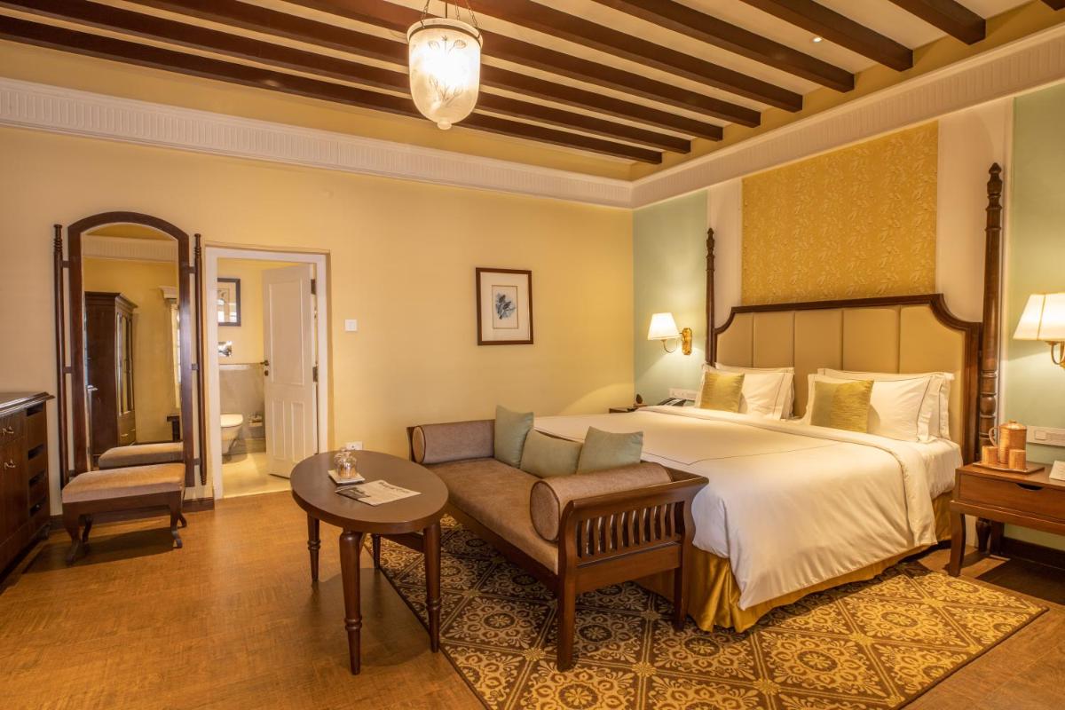 a bedroom with a bed and a couch and a table at Savoy - IHCL SeleQtions in Ooty