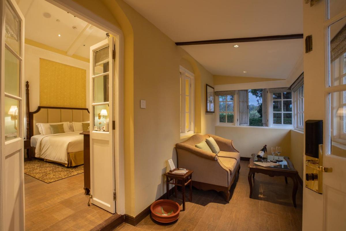 a bedroom with a bed and a couch and a chair at Savoy - IHCL SeleQtions in Ooty