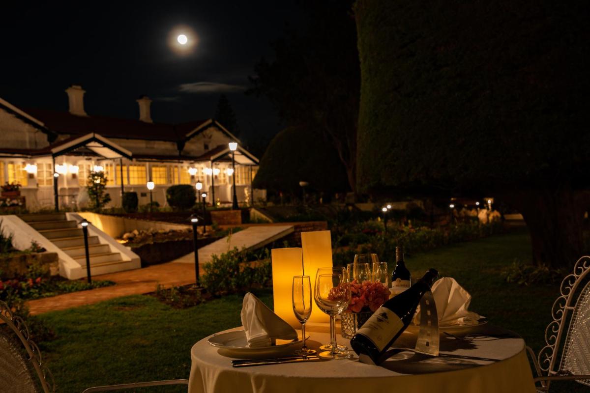 a table with a white table cloth and wine glasses at Savoy - IHCL SeleQtions in Ooty