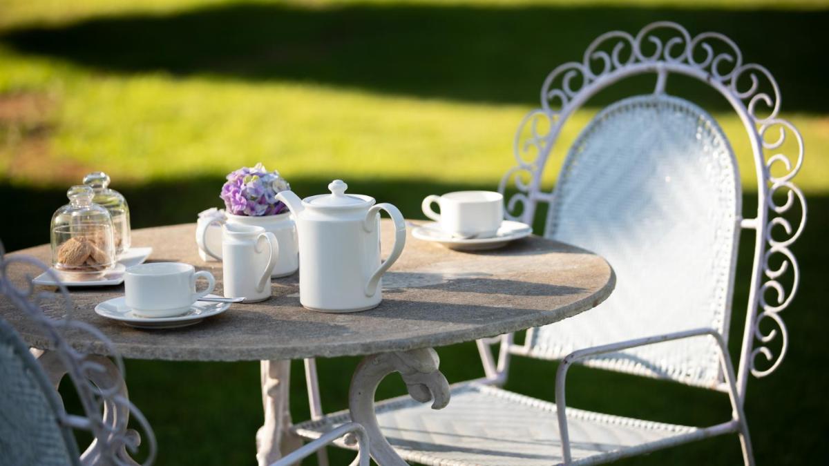 a table with cups and saucers on it at Savoy - IHCL SeleQtions in Ooty