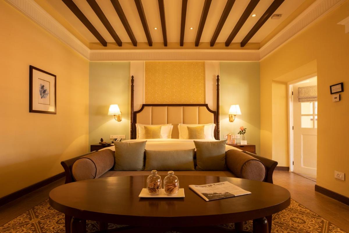 a living room with a couch and a bed at Savoy - IHCL SeleQtions in Ooty