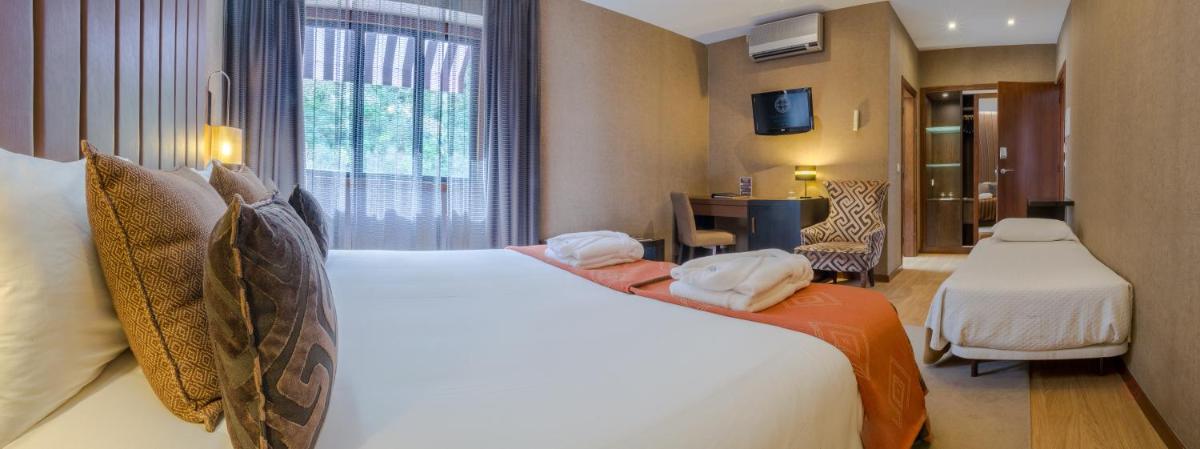 um quarto de hotel com uma cama grande e uma janela em Your Hotel & Spa Alcobaça em Alcobaça mais 107 fotografias
