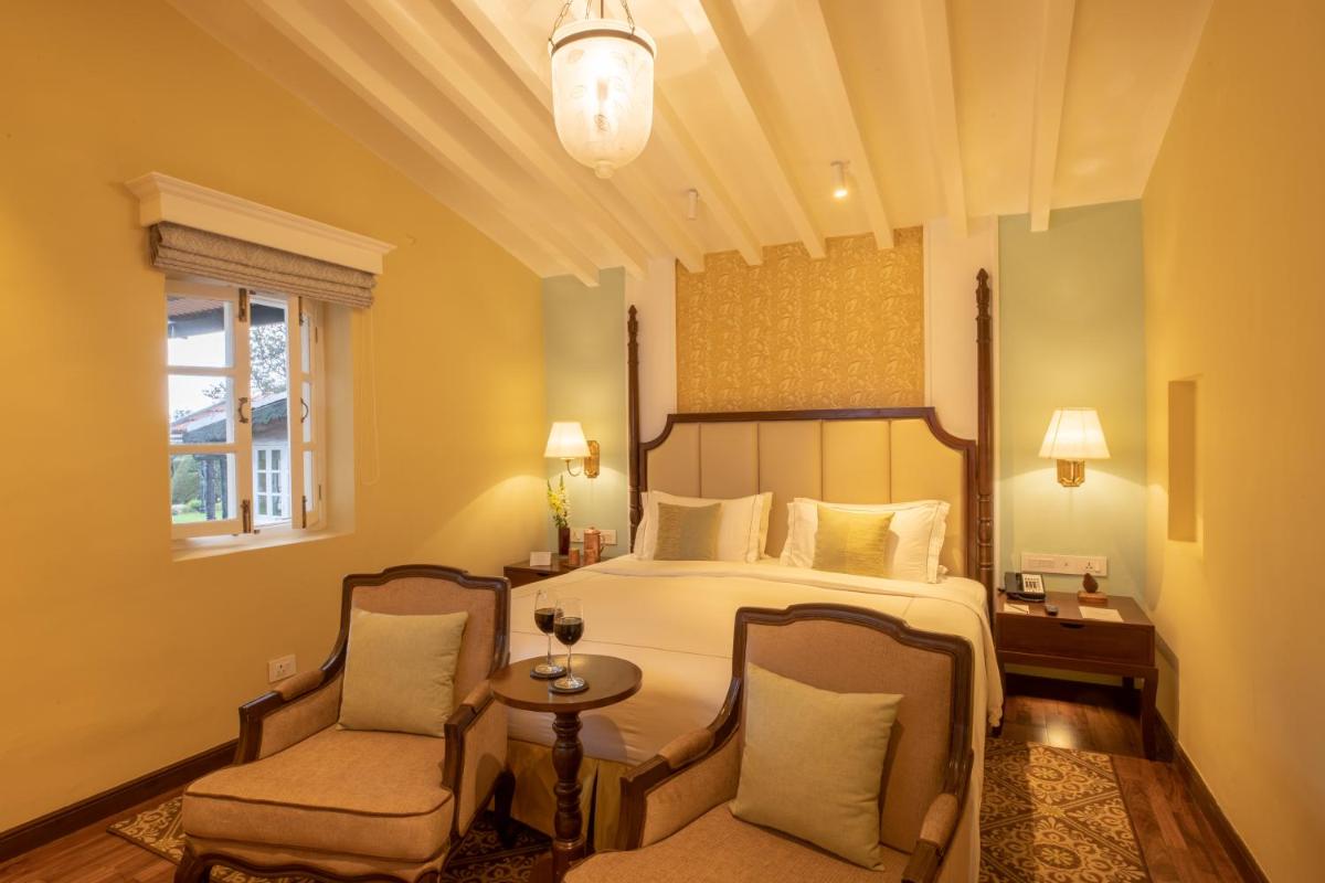 a bedroom with a bed and two chairs at Savoy - IHCL SeleQtions in Ooty