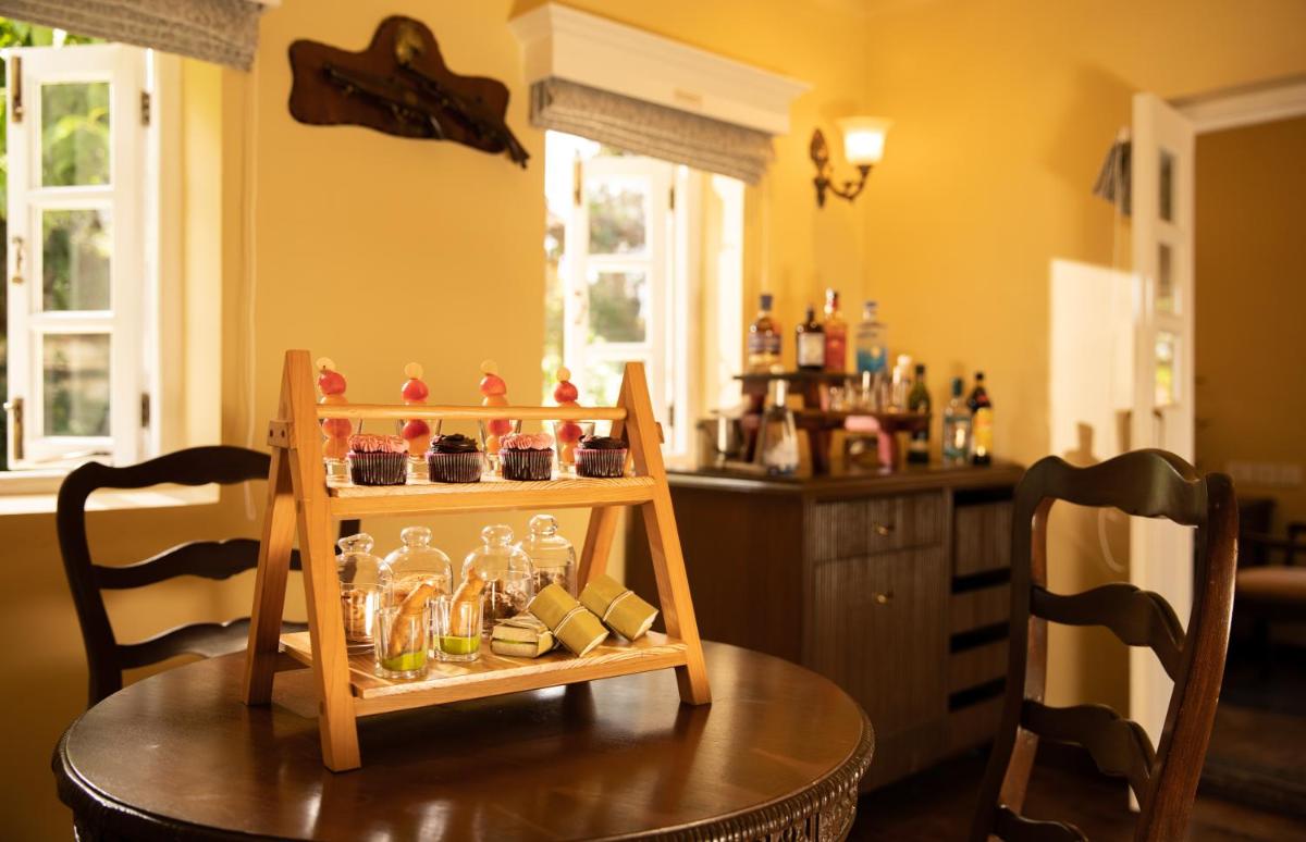 a table with a shelf of glass bottles on it at Savoy - IHCL SeleQtions in Ooty