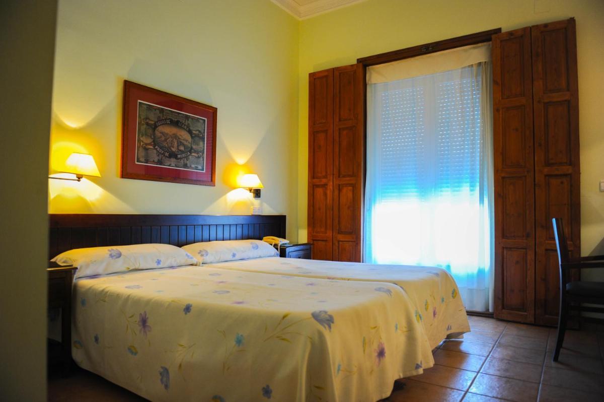 Un dormitorio con una cama grande y una ventana. en Hotel Victoria, en Fortuna