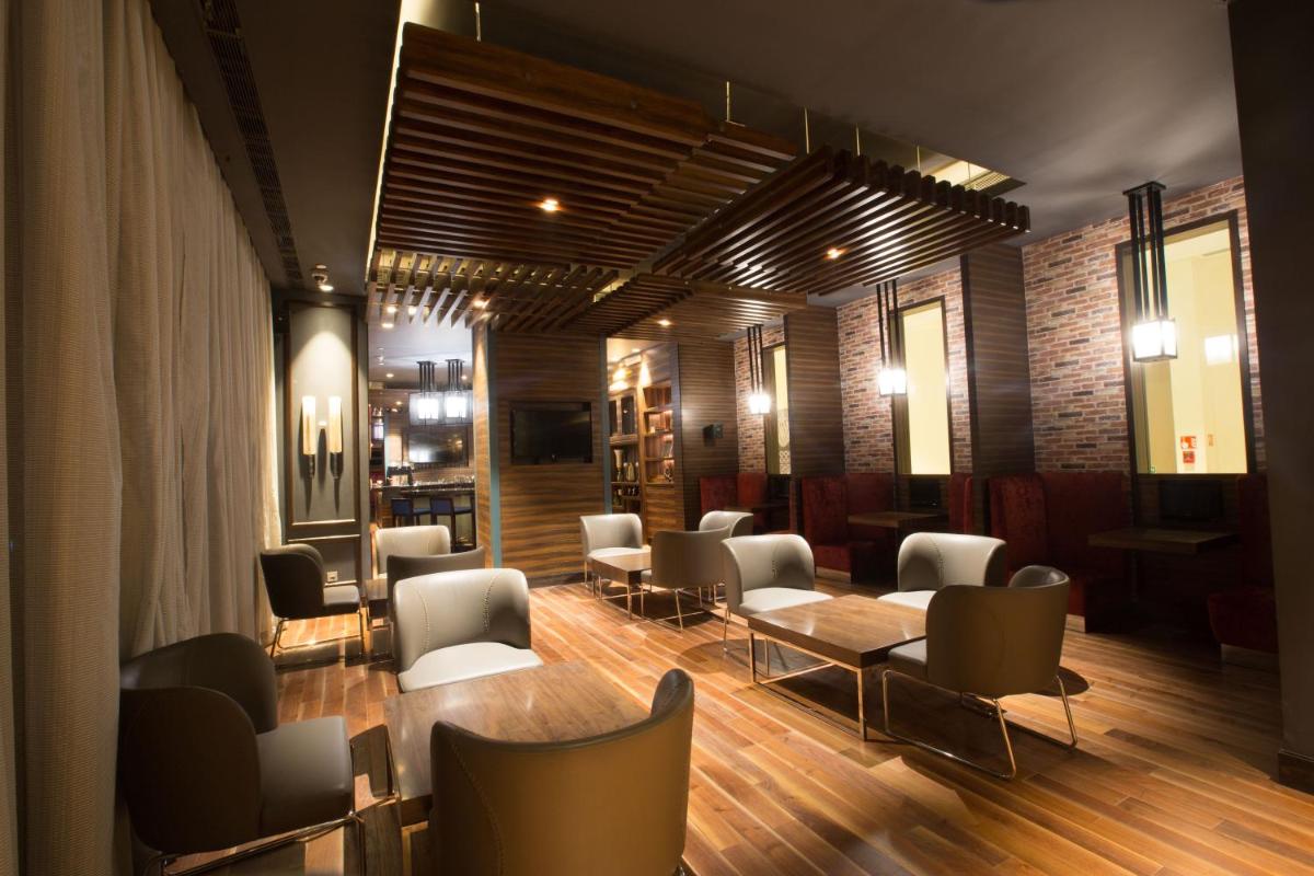 a waiting area with chairs and tables in a room at Holiday Inn Chennai OMR IT Expressway by IHG in Chennai
