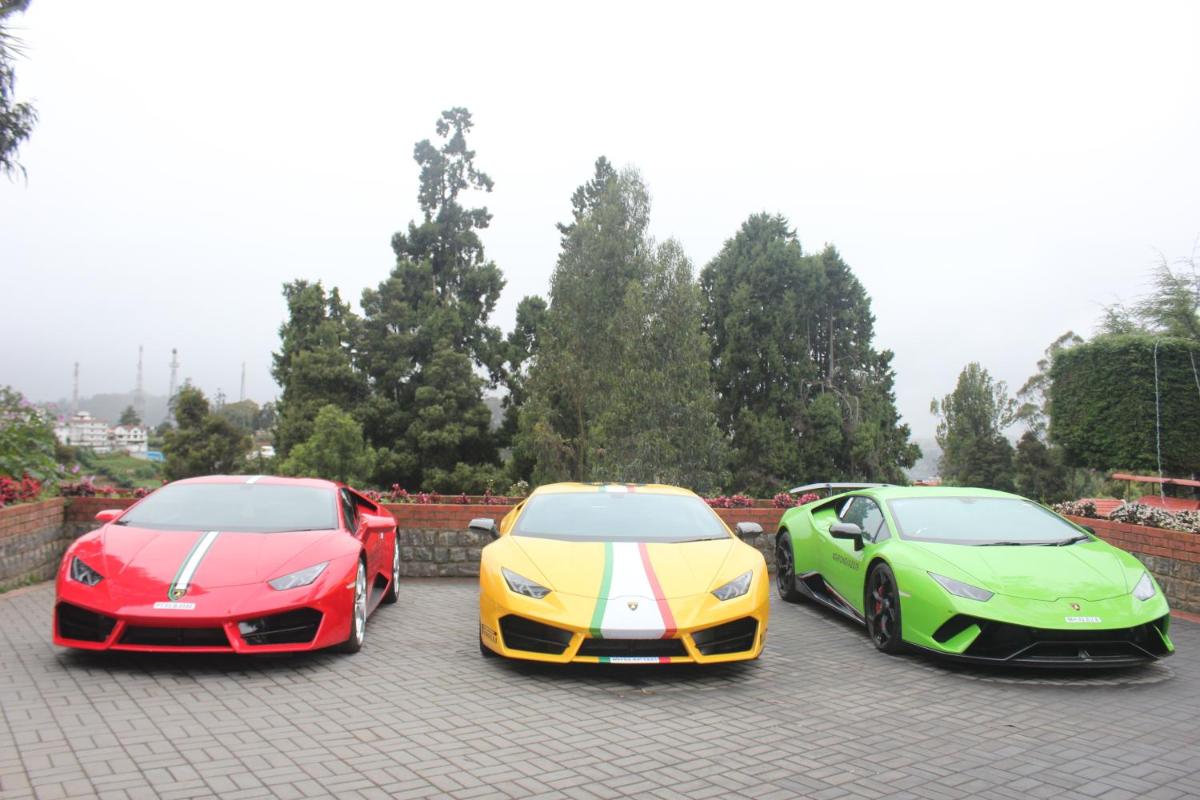 three expensive lamborghinis parked in a parking lot at Savoy - IHCL SeleQtions in Ooty