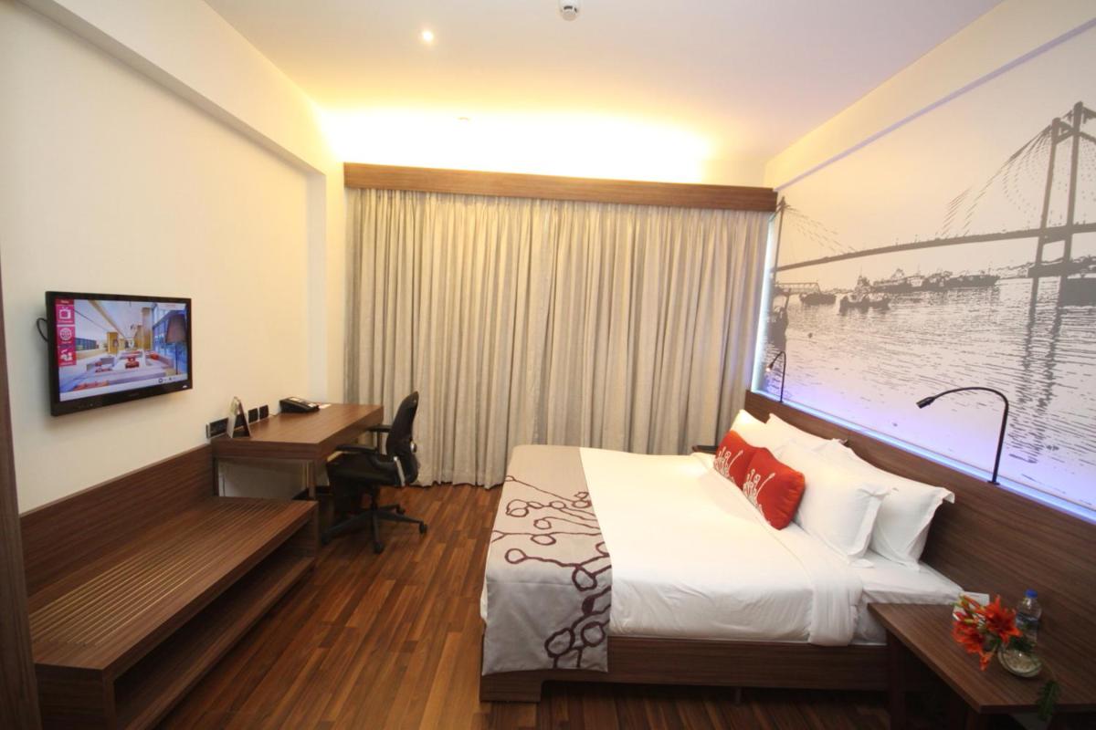 a hotel room with a bed and a desk in it at Vivanta Kolkata EM Bypass in Kolkata