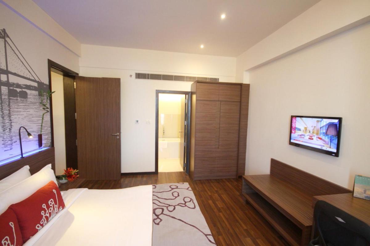 a bedroom with a bed and a television on a wall at Vivanta Kolkata EM Bypass in Kolkata