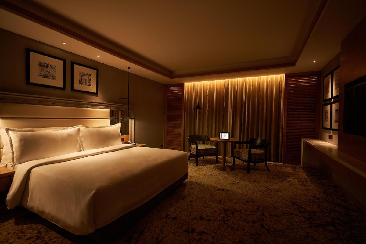 a hotel room with a large bed and a desk at The Residency Towers Puducherry in Puducherry