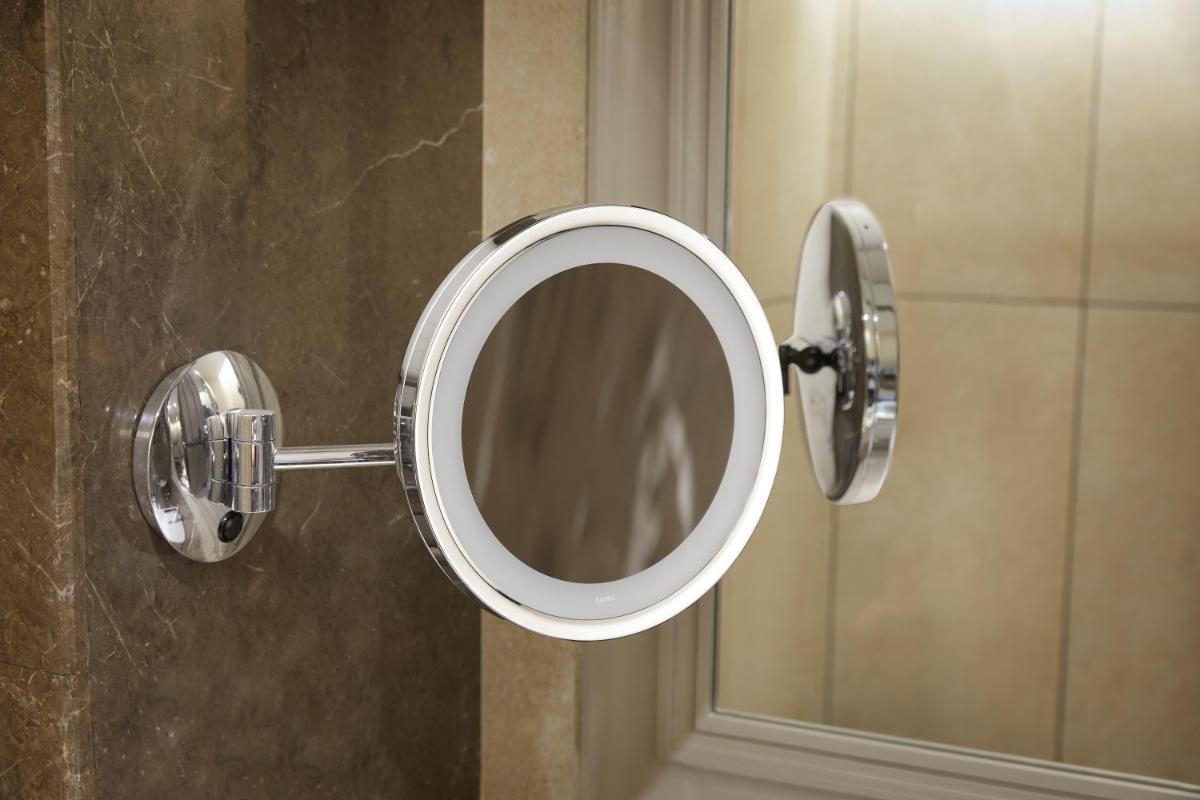 a mirror on a wall in a bathroom at The Residency Towers Puducherry in Puducherry