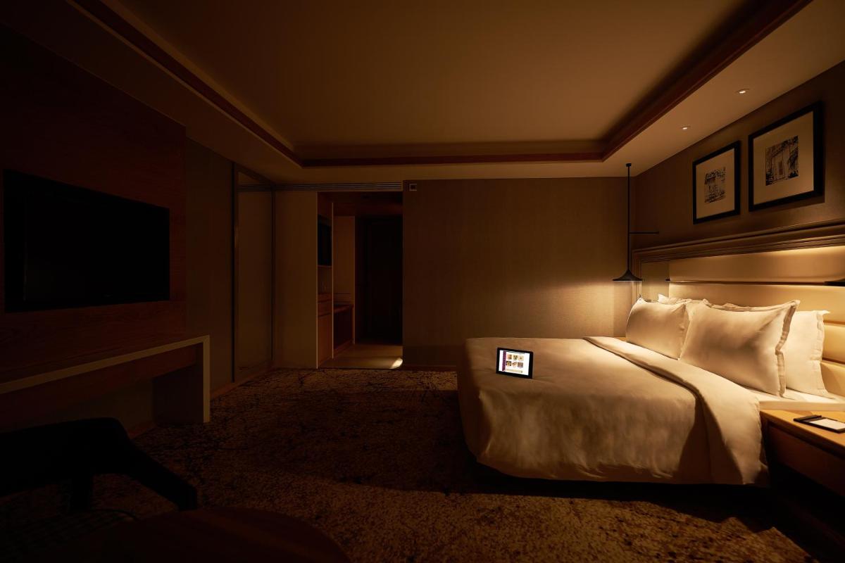 a hotel room with a bed and a television at The Residency Towers Puducherry in Puducherry
