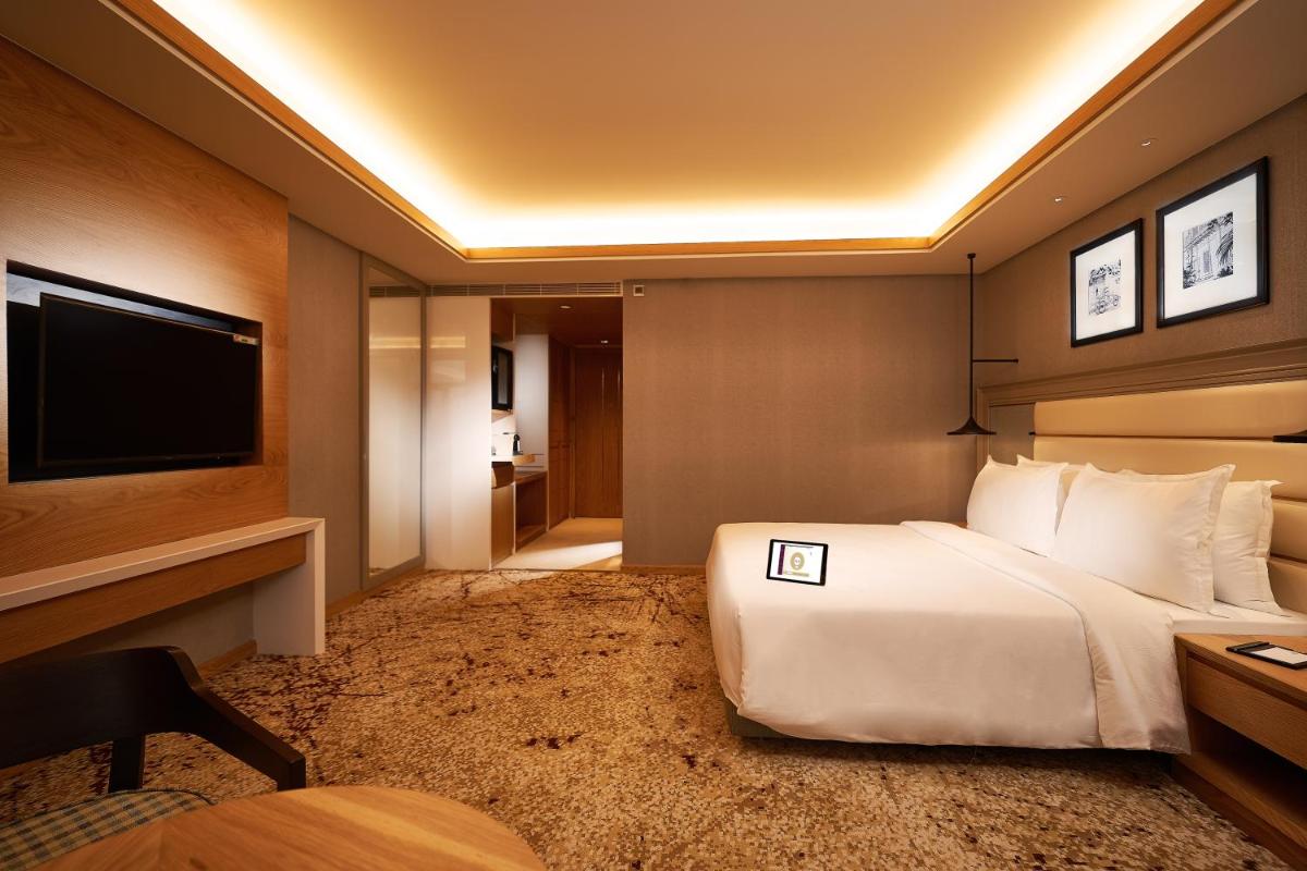 a hotel room with a bed and a television at The Residency Towers Puducherry in Puducherry
