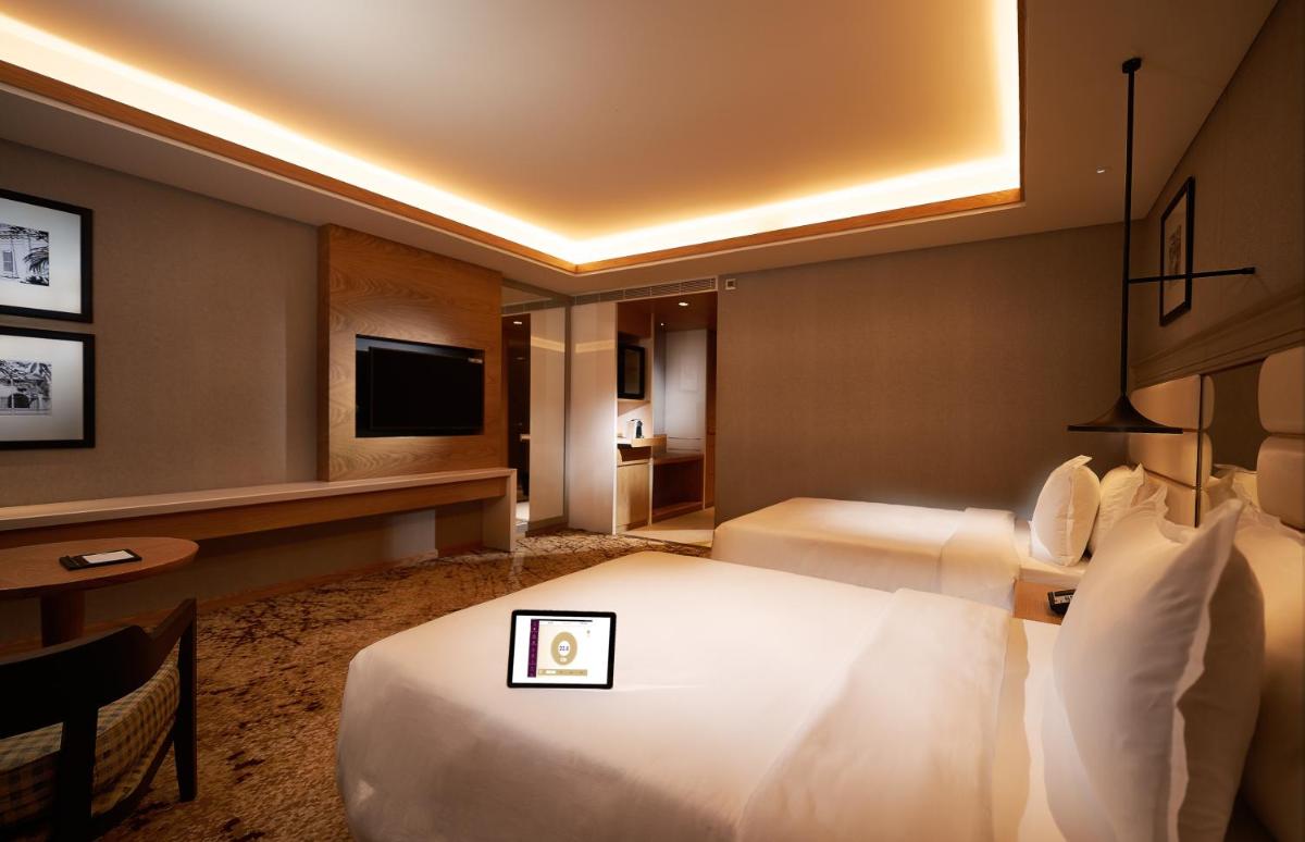 a hotel room with a bed and a tv at The Residency Towers Puducherry in Puducherry