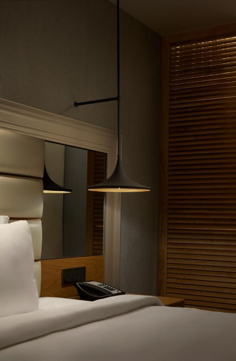 a bedroom with a bed and a mirror at The Residency Towers Puducherry in Puducherry