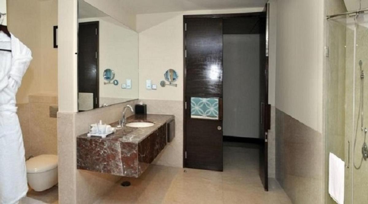 a bathroom with a sink and a toilet at Radisson Blu Plaza Hotel Mysore in Mysore
